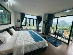 宁平Trang An Legend的一间卧室设有一张大床和大窗户