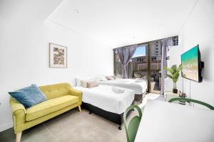 悉尼Arthur's Hotel Bondi Junction的一间带两张床和一张沙发的客厅