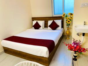商沙巴Hotel KP Suites Airport的一间卧室配有床、水槽和鲜花