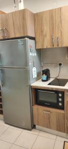 凯撒利亚Neot Golf Caesarea Garden Apartment的厨房配有不锈钢冰箱和微波炉。