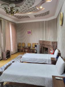 撒马尔罕SHAHNOZA GRAND的酒店客房设有两张床和壁炉