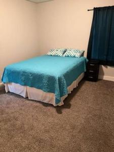 矿泉井城Serene 4 BR Home Near Weatherford-19 Minute Drive的一间卧室配有一张带蓝色棉被的床
