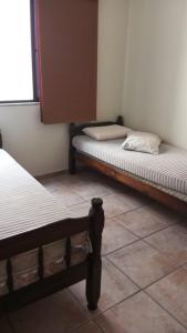 瓜拉派瑞ferratti的配有两张床的瓷砖地板客房