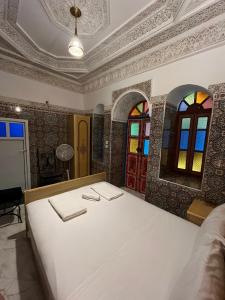 非斯Riad Fes Unique的配有床和彩色玻璃窗的房间