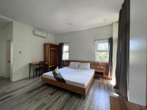 公主港蓝色泻湖酒套房酒店的一间卧室配有一张大床和一张书桌
