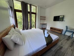 公主港蓝色泻湖酒套房酒店的卧室配有一张白色大床和电视。