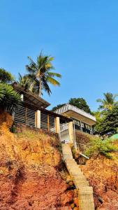 坎努尔Manshore bay的棕榈树悬崖顶上的房屋