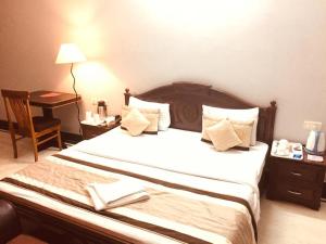 大诺伊达Angel NRI House的一间卧室配有一张带书桌和灯的床。