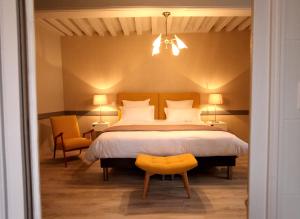 沙罗勒贝约汀庄园旅馆的一间卧室配有一张大床和一张黄色椅子