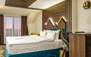 科帕奥尼克Harmonija Resort - Harmonia Palace的酒店客房,配有一张带木制床头板的床