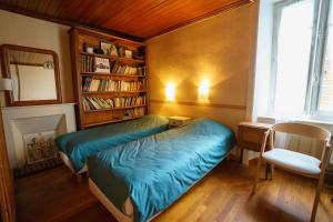 HirelParfum dEmbruns的一间卧室设有一张床和一个书架