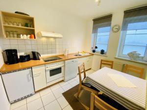 瓦尔内明德Landhaus Immenbarg, Warnow的厨房配有白色家电和桌子