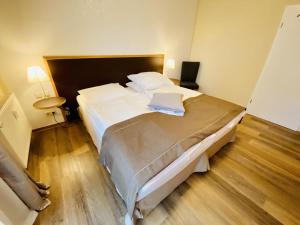 瓦尔内明德Landhaus Immenbarg, Warnow的卧室配有一张带白色床单和枕头的大床。