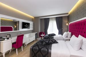 伊斯坦布尔登城SPA酒店 的酒店客房设有一张大床和红色床头板