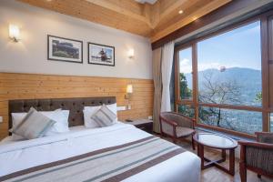 甘托克Summit Alpine Abode Hotel Centrally Air Conditioned的一间卧室设有一张床和一个大窗户