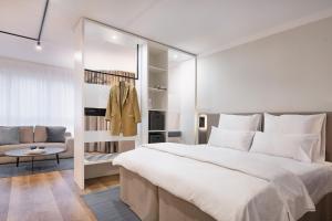 柏林阿姆勃兰登堡门公寓的卧室配有一张白色的大床和一张沙发。