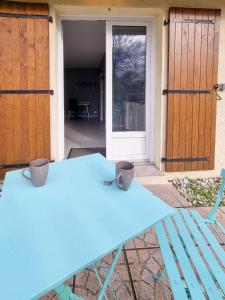 佩萨克Studio avec terrasse privative的门前有两壶的蓝色桌子