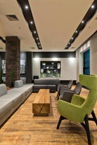 圣保罗Apart Hotel Ibirapuera的客厅配有沙发、椅子和桌子