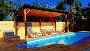 潘托皮芒Jolie Villa Santa avec piscine的一个带椅子的游泳池和一个凉亭
