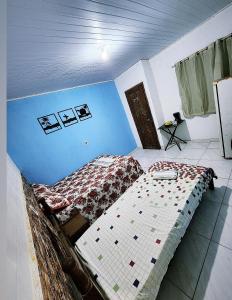 瓜拉派瑞Pousada Dule的一间卧室设有一张床和蓝色的墙壁