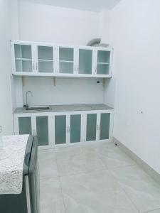 芹苴HOATEL MEKONG HOME GUESTHOUSE的厨房配有白色橱柜和水槽
