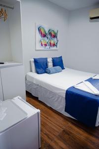若昂佩索阿Pousada Tropical Bessa的一间卧室配有两张带蓝色枕头的床