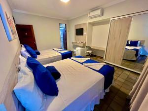若昂佩索阿Pousada Tropical Bessa的酒店客房 - 带两张带蓝色枕头的床