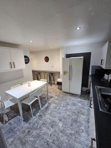 利物浦Melior Grandiose的厨房配有白色的桌子和冰箱。