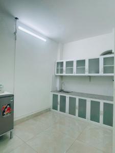 芹苴HOATEL MEKONG HOME GUESTHOUSE的一间空房间,设有白色的墙壁和绿色的橱柜