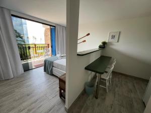 萨尔瓦多地平线乡村公寓的客房设有书桌、床和窗户。