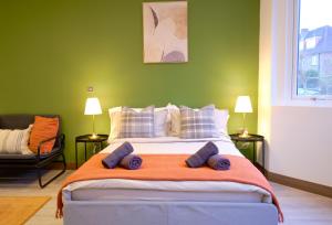 伦敦GoldersGreen Apartments by Sleepy的绿色卧室配有一张带蓝色枕头的大床