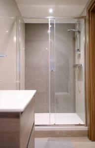 伦敦GoldersGreen Apartments by Sleepy的浴室里设有玻璃门淋浴