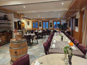 勒布拉索斯Hôtel Restaurant du Marchairuz的一间带桌椅和酒桶的餐厅
