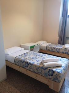 米兰米兰洛雷托精英酒店的一间设有两张床铺和毛巾的房间