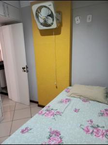 萨尔瓦多2/4, Barra. Lindo.的一间卧室配有一张带风扇和黄色墙壁的床。