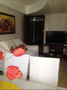 萨尔瓦多2/4, Barra. Lindo.的客厅,玻璃桌上摆放着红色的鲜花