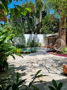 托兰克索Hotel Boutique Vila São João的花园设有游泳池、长凳和树木