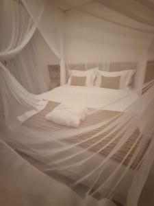 托兰克索Hotel Boutique Vila São João的一间卧室配有带白色床单和枕头的床。