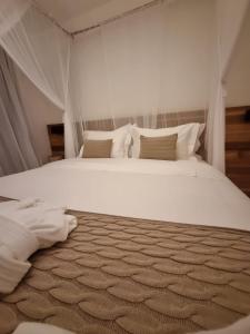 托兰克索Hotel Boutique Vila São João的卧室配有一张带白色床单和枕头的大床。