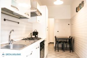 丽都迪奥斯蒂亚特拉蒙塔纳公寓的厨房配有水槽和桌子