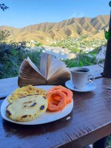 塔甘加Tamarindo Beach hostel的盘带书和咖啡的食物