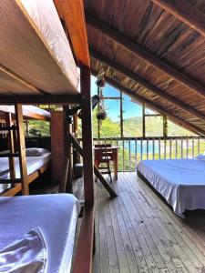 塔甘加Tamarindo Beach hostel的大型木制甲板配有两张床和一张桌子