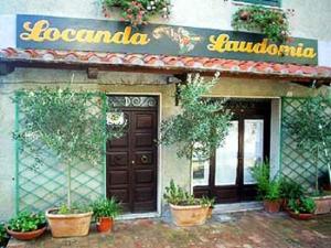曼恰诺洛堪达劳多米亚酒店的楼前有盆栽植物的餐厅