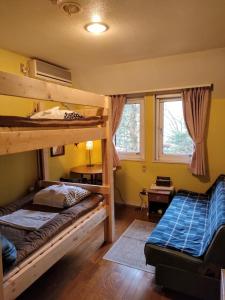 轻井泽Bellscabin Guesthouse的一间卧室配有两张双层床和一张书桌