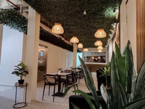巴拿马城HOTEL BALUARTE BOUTIQUE PANAMA的一间设有桌椅和盆栽的餐厅