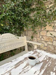 阿拉恰特塞林酒店 的坐在长凳旁边的桌子上喝杯咖啡