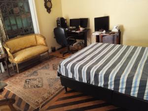 里约热内卢Estúdios Deluxe São Manuel的一间卧室配有一张床、一把椅子和一张书桌