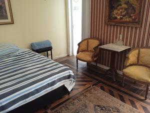 里约热内卢Estúdios Deluxe São Manuel的一间卧室配有一张床、两把椅子和一张桌子