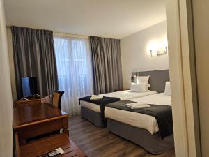 埃维昂莱班布尔格尼酒店的酒店客房配有两张床和一张书桌