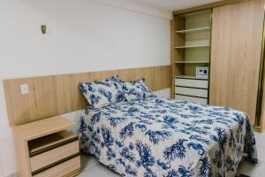 帕纳米林APART Alto padrao praia PIRANGI的一间卧室配有一张带蓝白色毯子的床